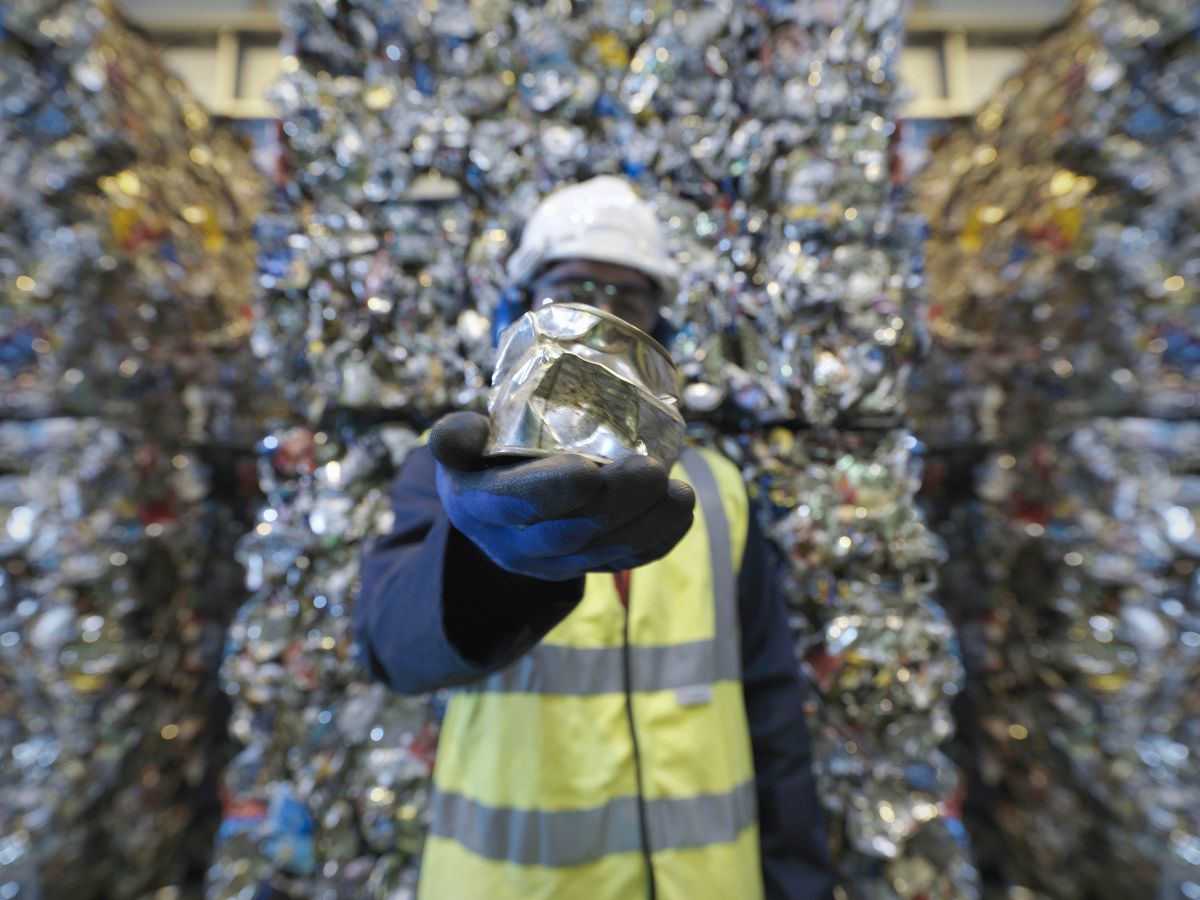 Worker Holding Can In Recycle Plant